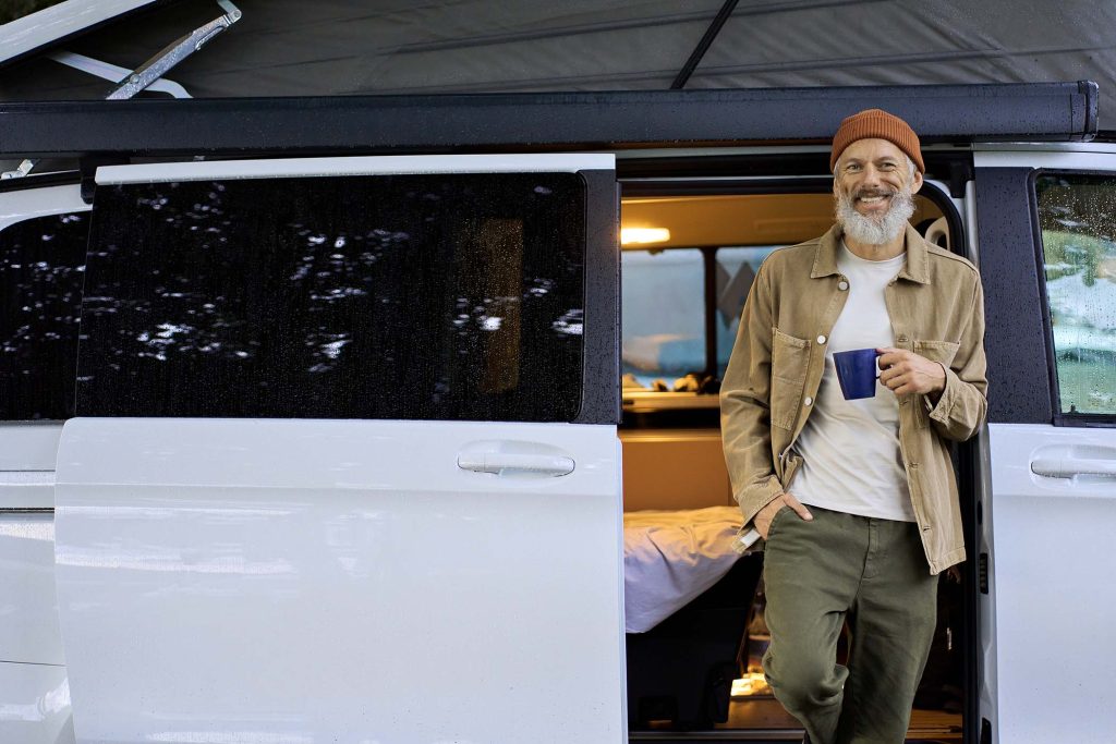 happy-old-man-traveler-standing-near-camper-van-dr-8ZJVU7P.jpg